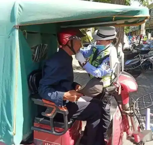 我为群众办实事中卫交警手把手为骑行者戴好安全头盔
